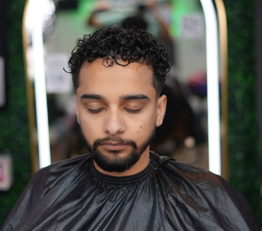 Front view of a curly perm with a soft taper