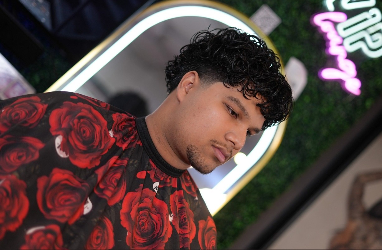 Client in a rose print cape with a fresh curly perm