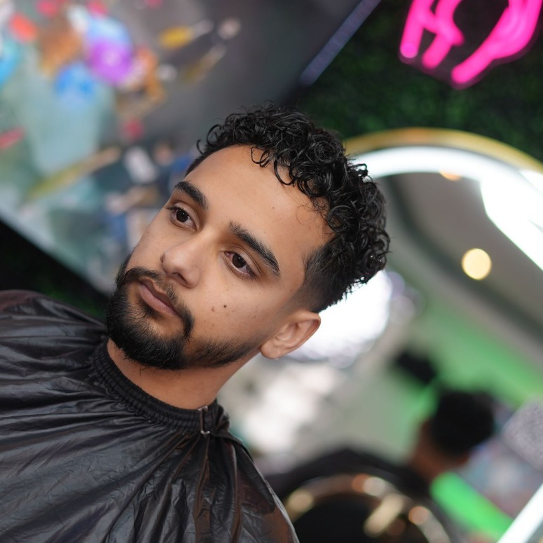 Three quarter view of loose curls and a trimmed beard