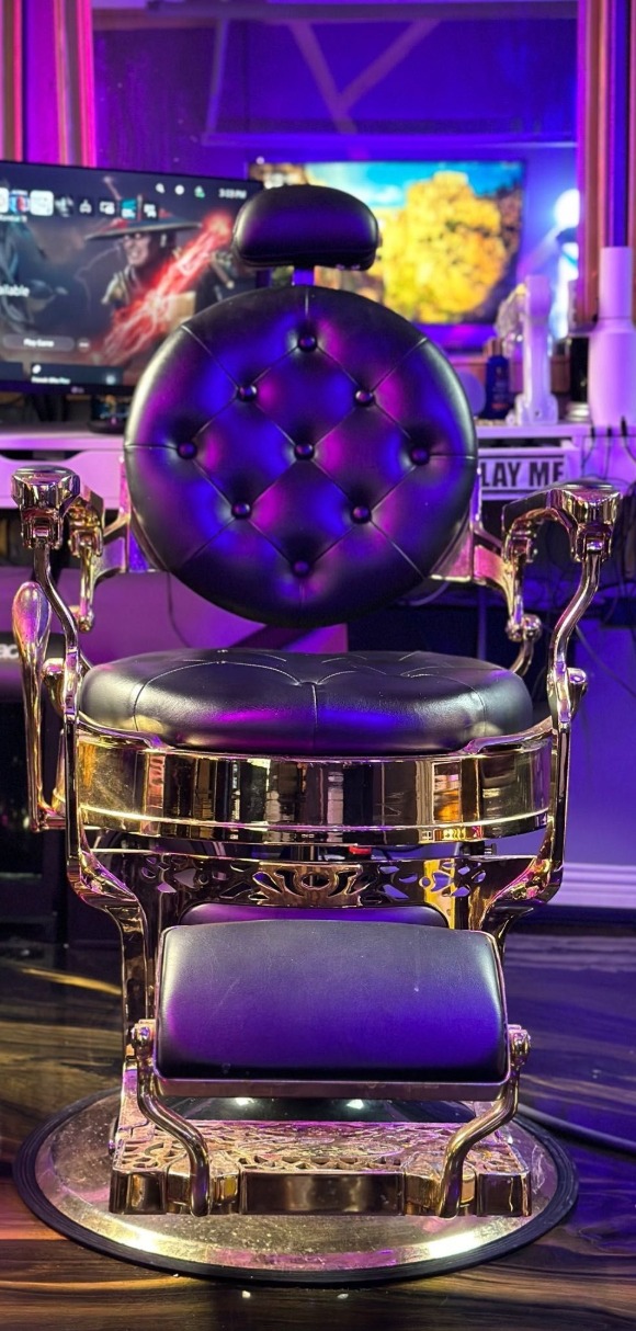 The studio's tufted leather barber chair with a polished gold frame