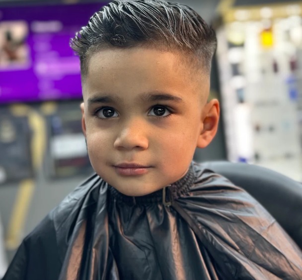 Young boy smiling after a textured kids' cut with a clean fade