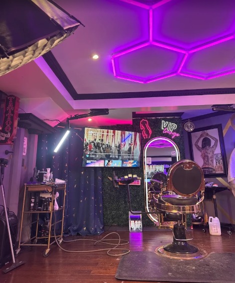 The studio under a violet hexagon light ceiling, with the gold chair facing a lit mirror