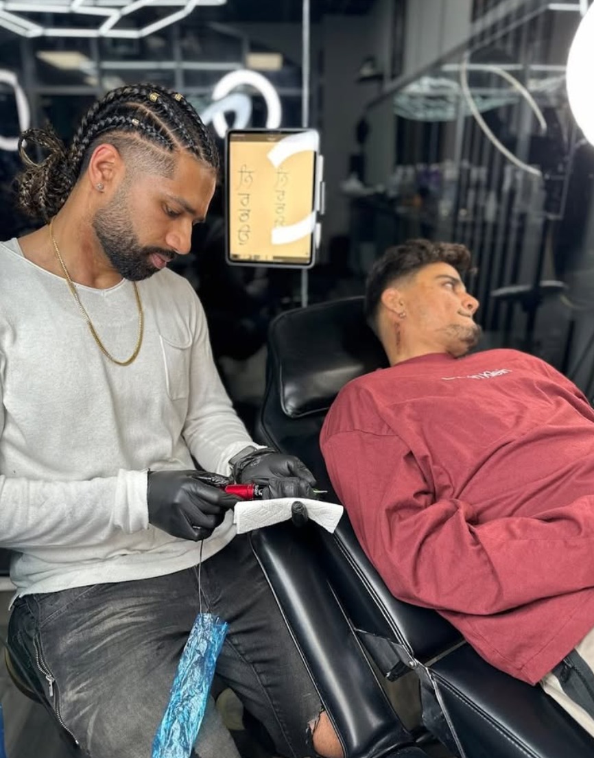 Vickram tattooing a client reclined in the tattoo chair
